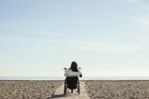 back-view-of-woman-in-wheelchair-at-the-beach accesibilite-handicap-erasmus