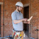 An electrician contractor examines a blueprint at a construction site. Mobilité Erasmus construction